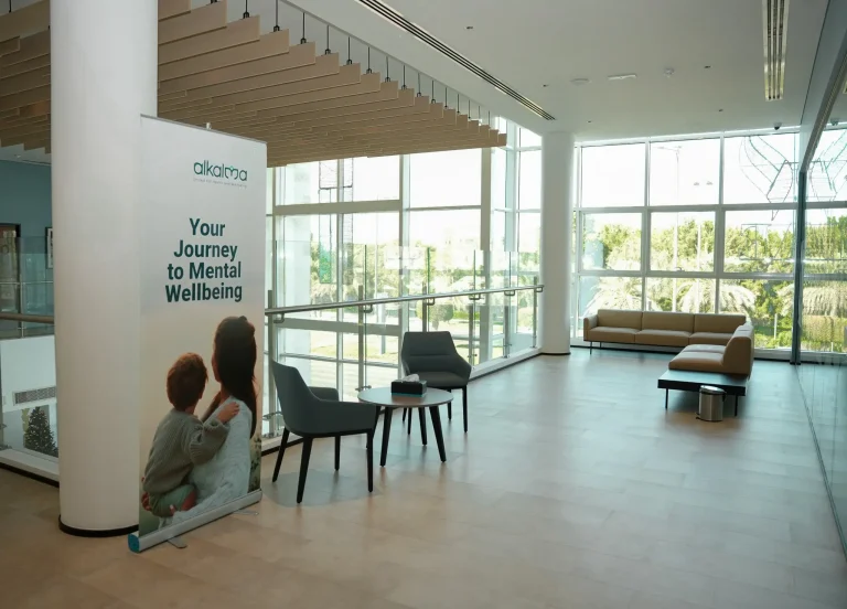 Atrium waiting area at the alkalma Al Bateen clinic with a 'Your Journey to Mental Wellbeing' banner