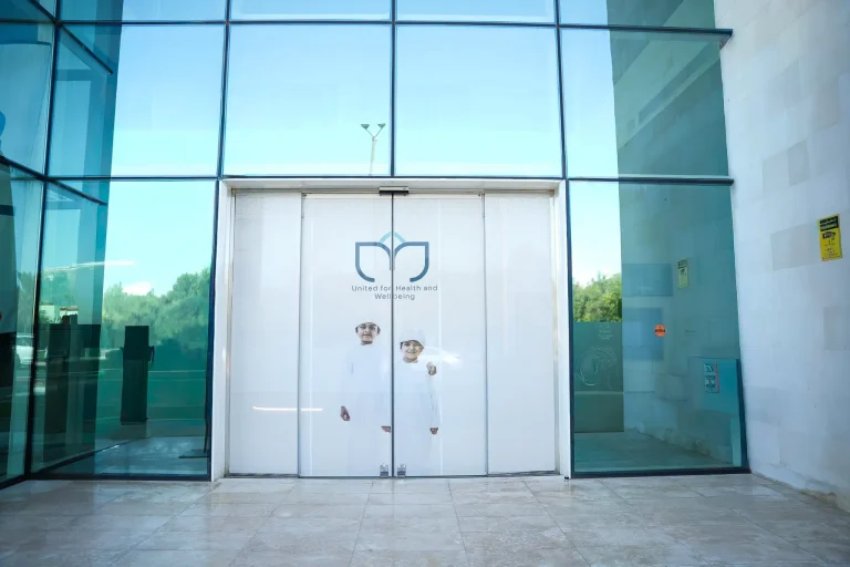 Main entrance to the alkalma Al Bateen clinic, with the alkalma logo on the glass doors