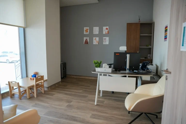 Consultation room at the alkalma Al Falah clinic with a clinician's desk and a child-sized table and chairs
