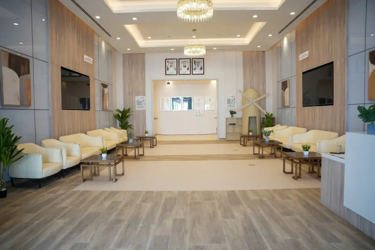 Main reception hall at the alkalma Al Falah clinic with cream sofas and a chandelier above the waiting area