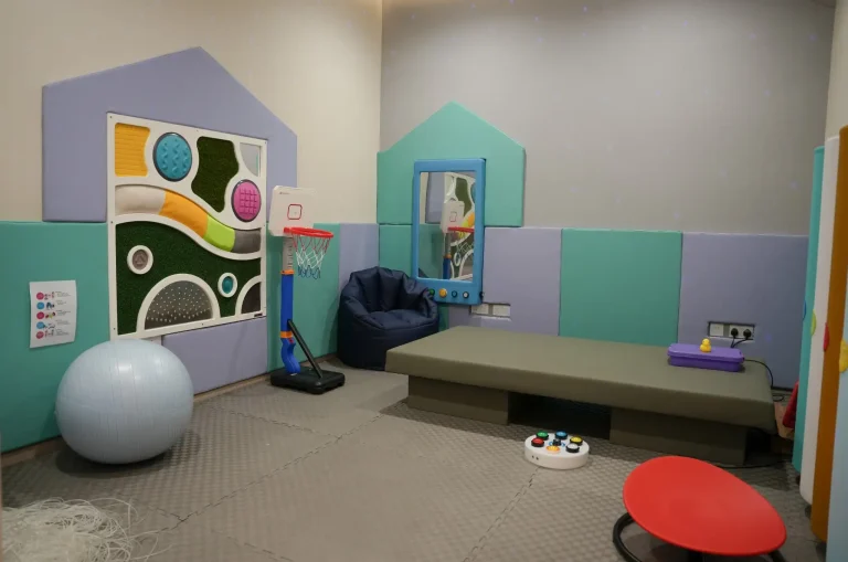 Children's sensory room at the alkalma Al Falah clinic with soft play mats, a gym ball and a basketball hoop