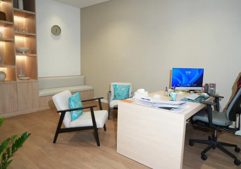 Clinician's consulting office at the alkalma Dubai clinic with a desk, monitor and backlit shelving