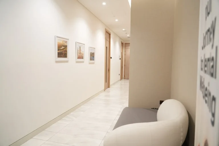 Corridor at the alkalma Dubai clinic lined with framed artwork leading to the treatment rooms